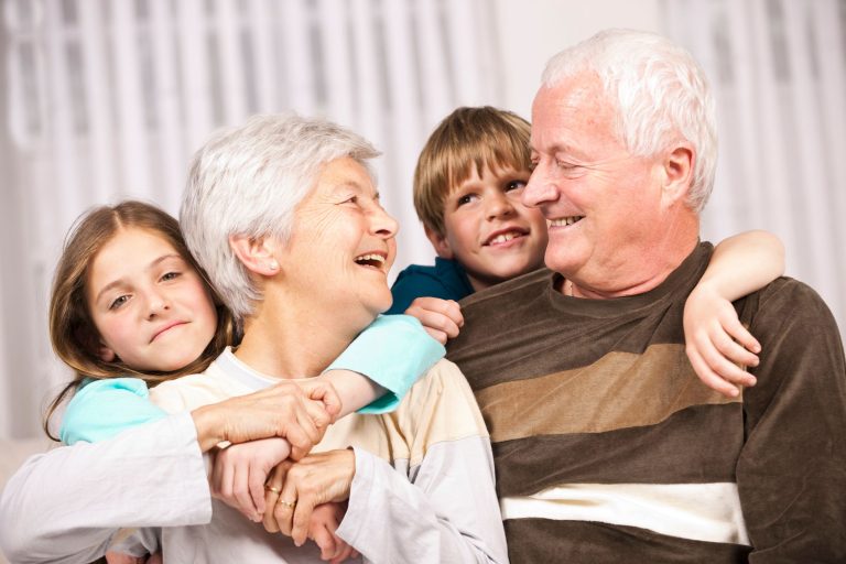Grandparents smiling with grandkids cuddling them