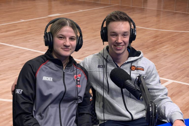 Emma Caeran and Bailey Dyer from NBL1 on front of a microphone