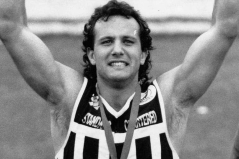 Blac and White photo of Georgia Fiacchi wearing. medal after winning wearing a port adelaide magpies Footy Guernsey