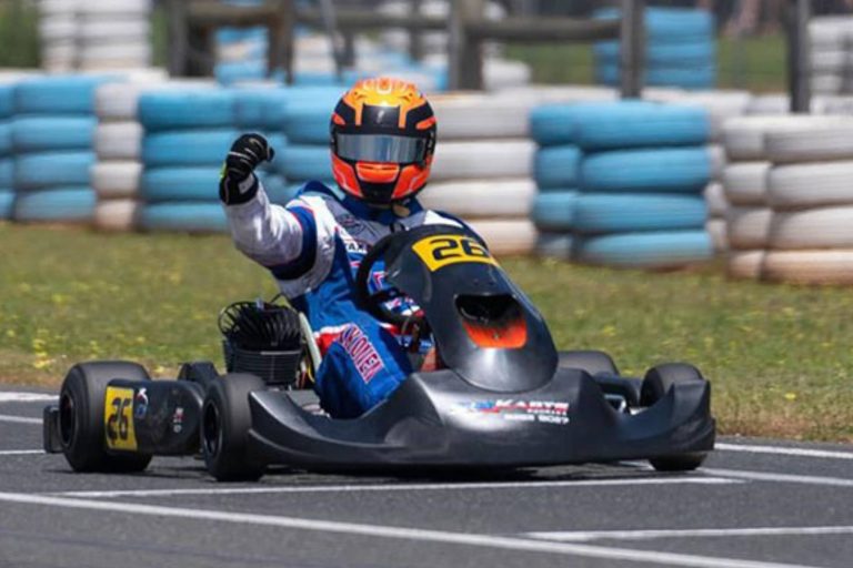 Leigh Harrison racing over the finish line in a go-kart