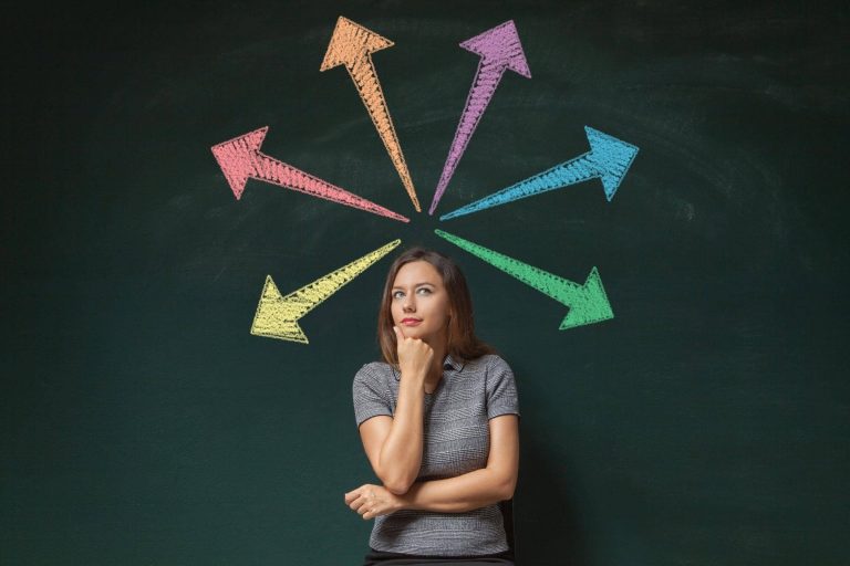 A lady thinking about making a decision in front a black background with colourful arrows abover her head