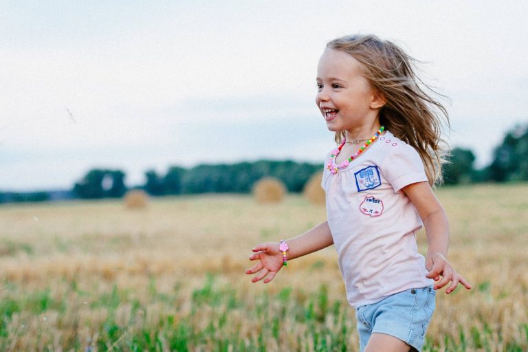 A child running through a field smiling