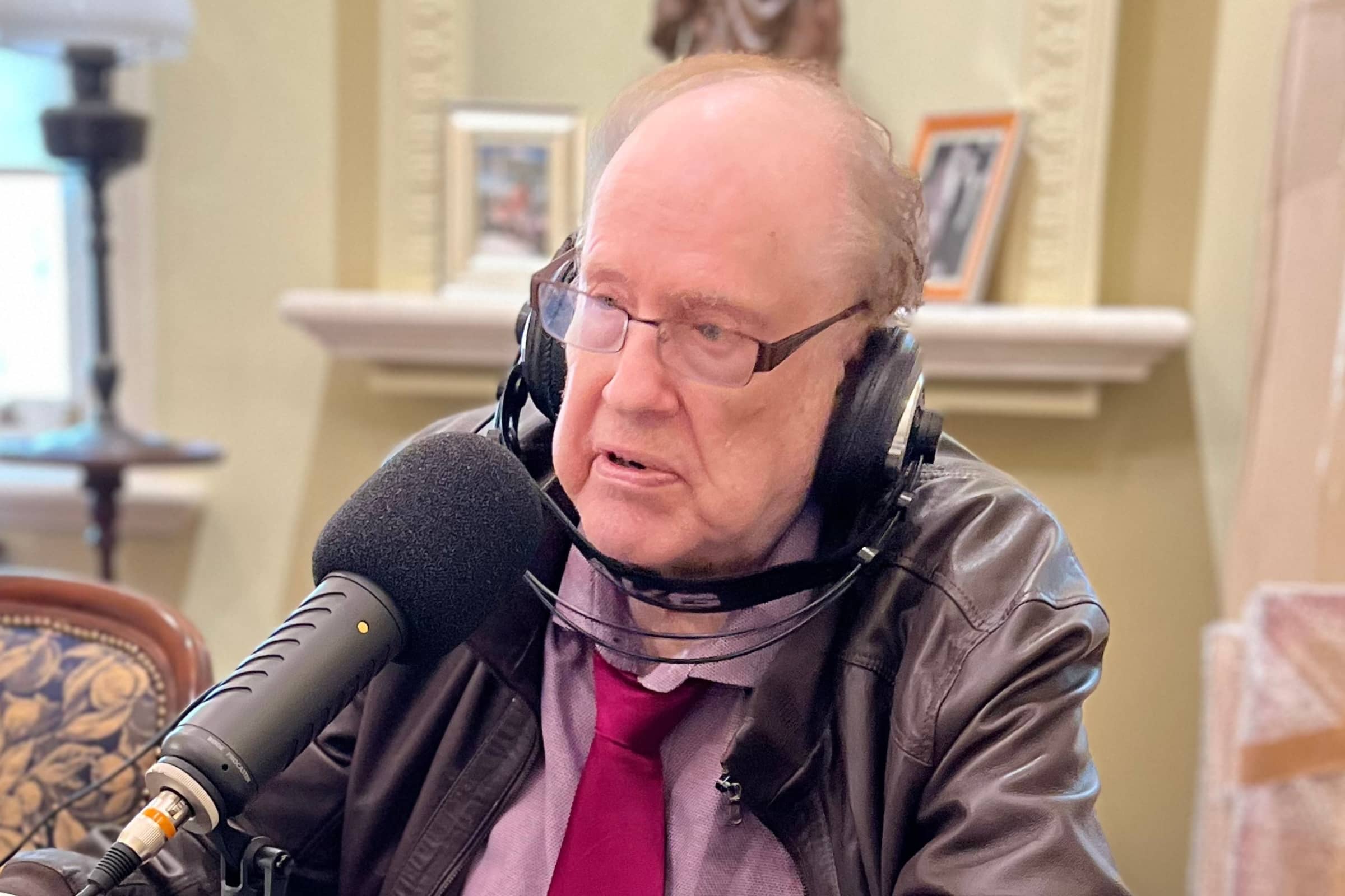 Legendary Radio Presenter Leon Byner at the dining room table wearing headphones