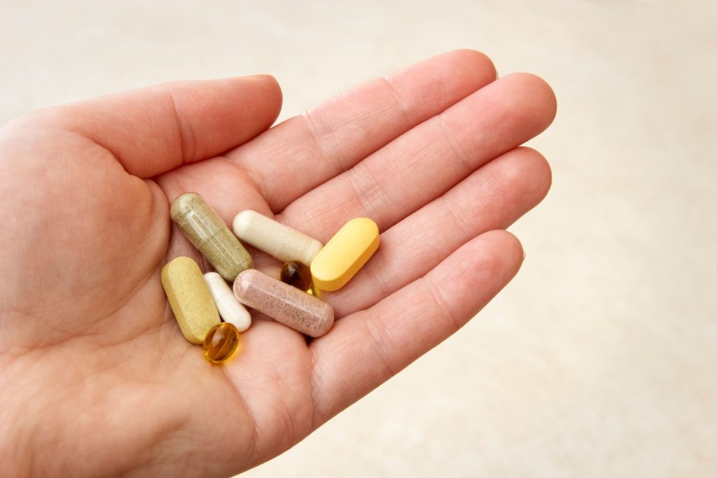 A hand holding some vitamins. The vitamin industry is booming, but are these supplements really worth the investment?