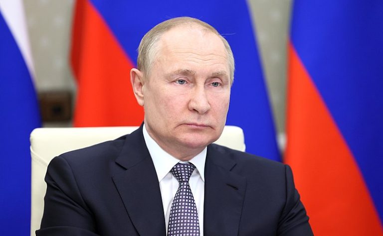 Vladimir Putin looking stern in front of flags