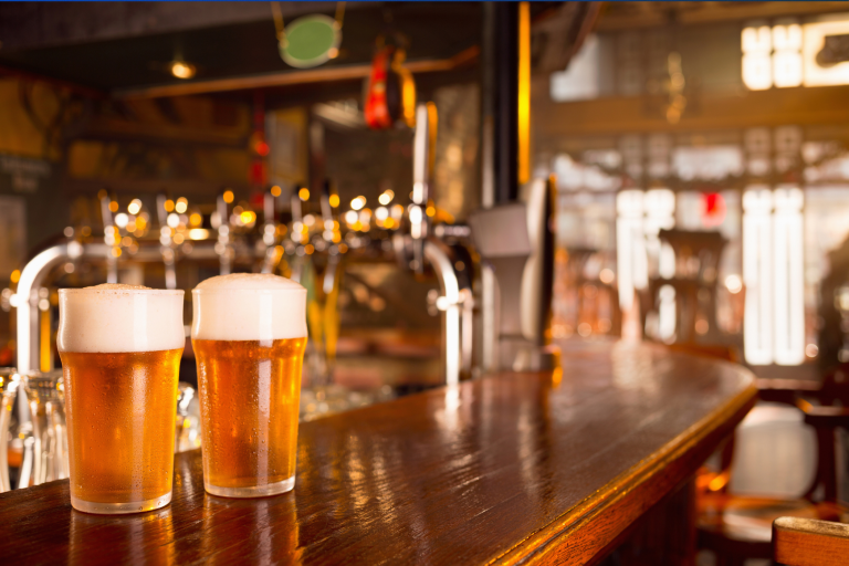 2 glasses of beer on the bar of a country pub