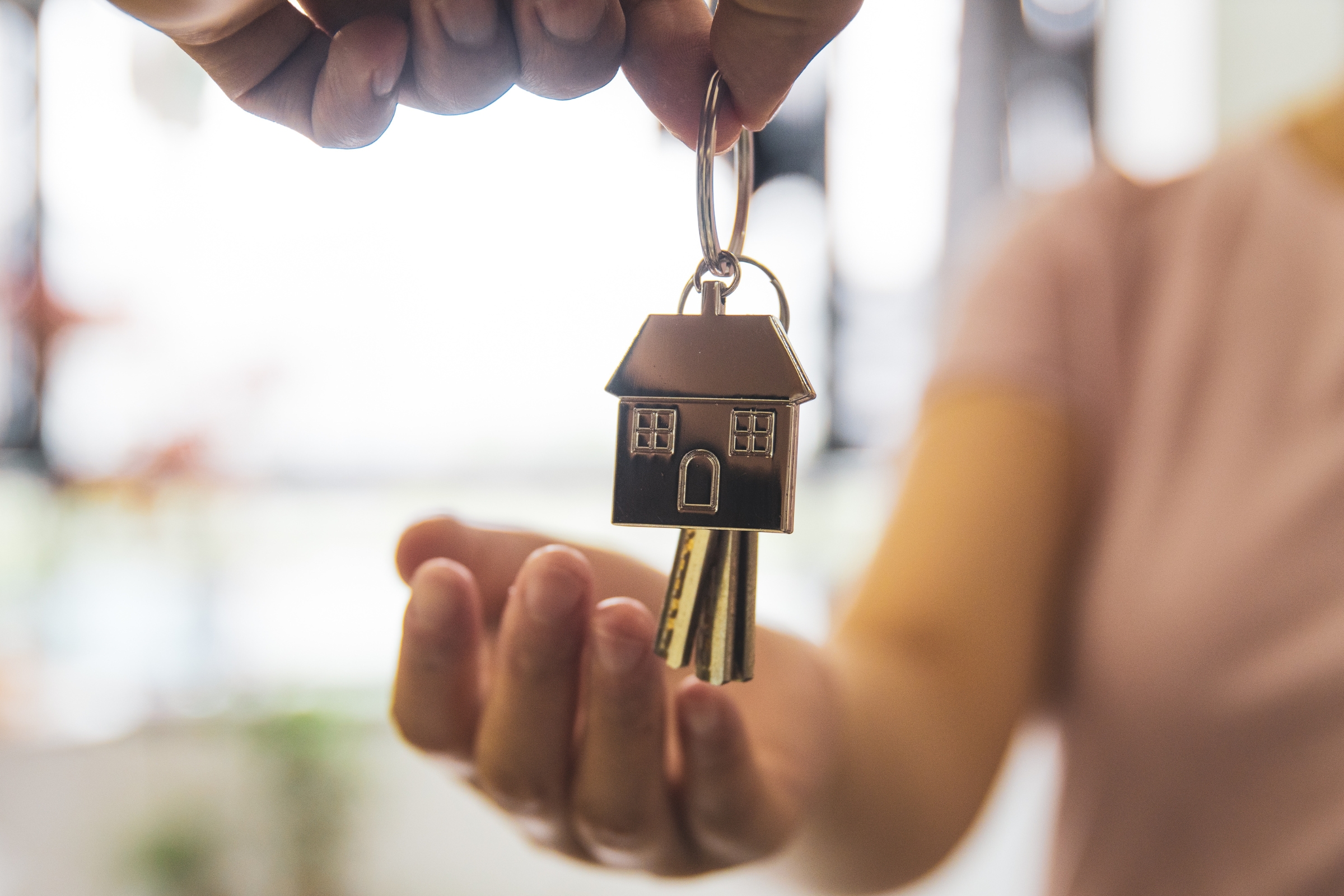 A set of house keys being put into the hand or a first-time buyer