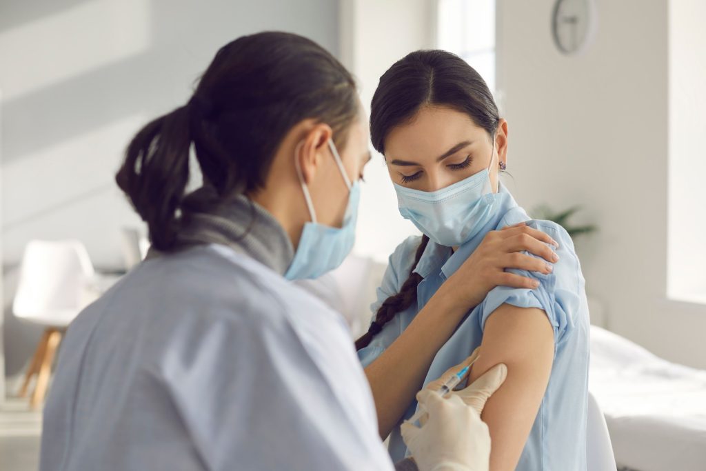 A Medical professional supplying a vaccine to a female patient