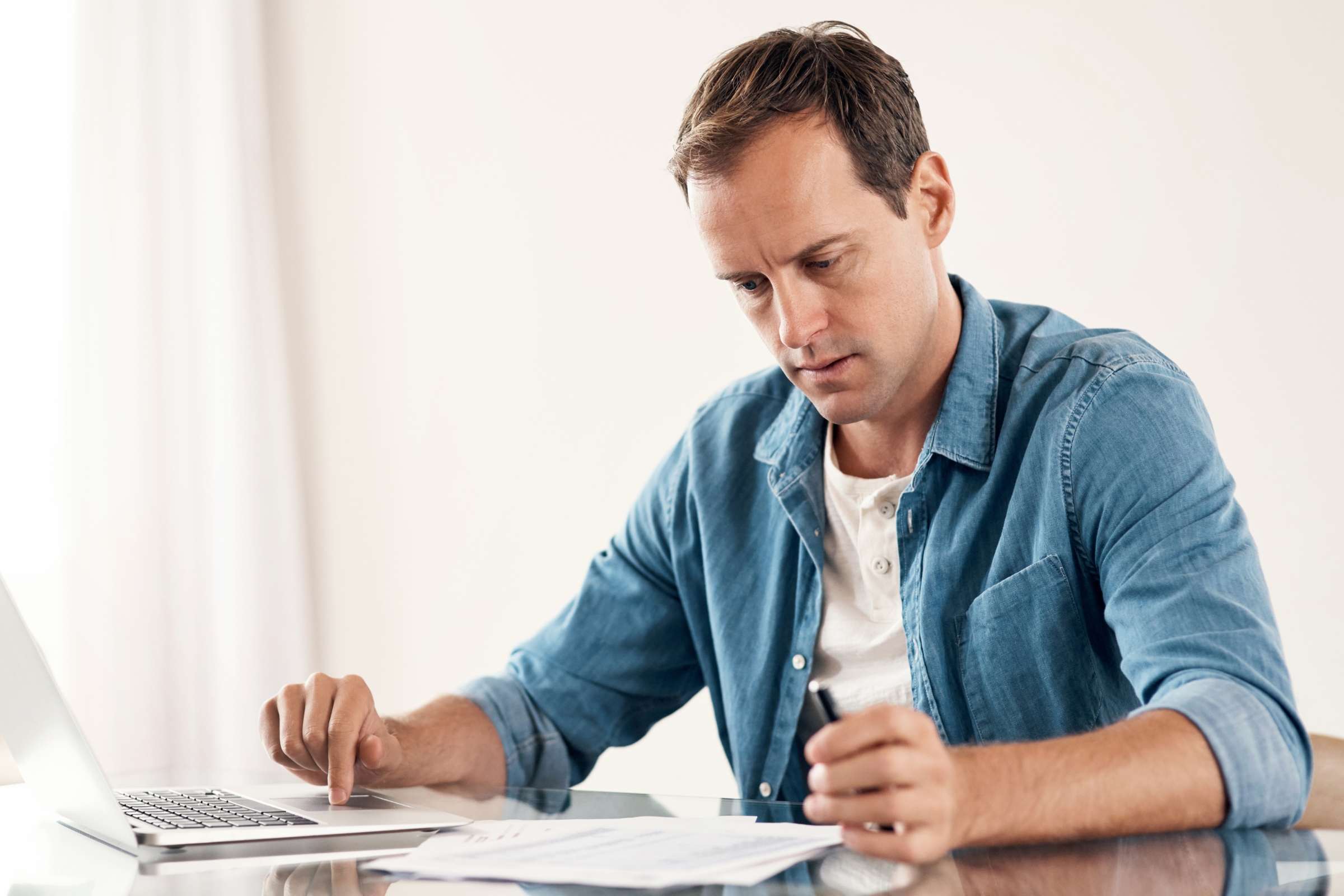 A guy looking at his bills looking worried